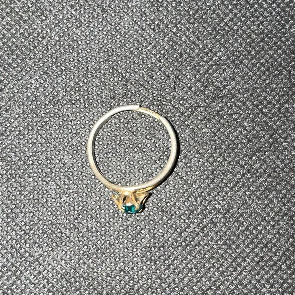 Adjustable metal ring with green gem